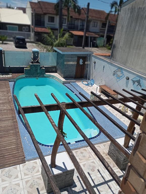 a swimming pool with a wooden fence around it at imovel 2 e 3 in Guaratuba