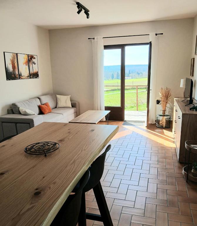a living room with a table and a couch at Gîte rural indépendant in Barbaste