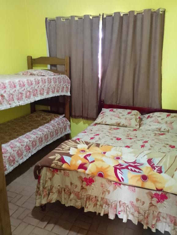 a bedroom with two bunk beds and a window at Casa simples em cunha in Cunha