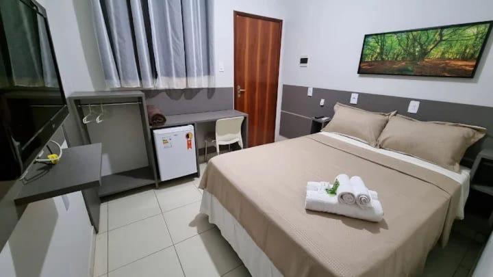 a bedroom with a bed with a towel on it at Pousada Aconchego in Duas Estradas