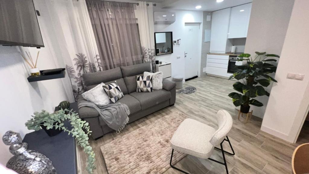 a living room with a gray couch and chairs at Villamadrid Home in Madrid
