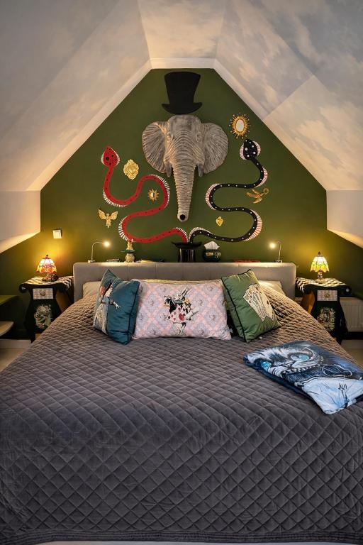 a bedroom with a bed with an elephant on the wall at Wonderland21 - Appartement entier 4 personnes - B&B - 7 min Disneyland Paris in Saint-Germain-sur-Morin