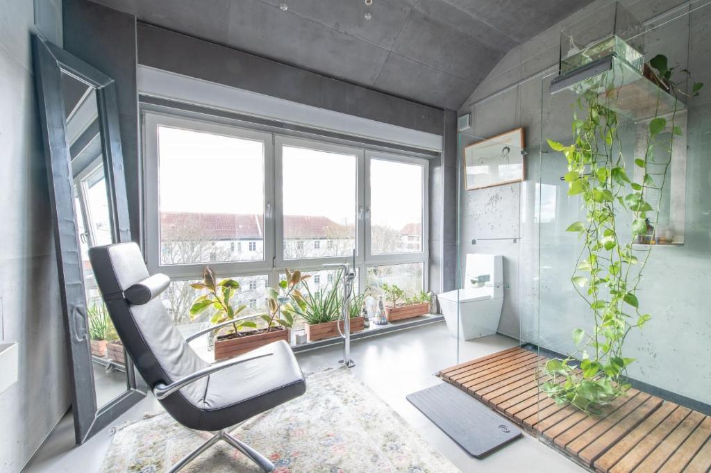 a office with a chair and plants in a room at Stylish Loft Apartment with Designer Bathroom & Balcony in Berlin
