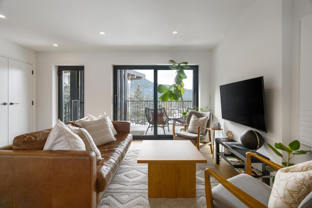 a living room with a couch and a tv at Spacious 2BR Retreat, Scenic Views, Modern & New in Whistler
