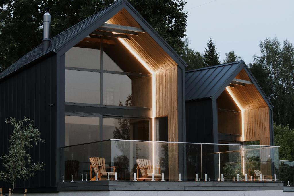 a house with a black roof and glass at WakeMālpils brīvdienu mājas in Mālpils