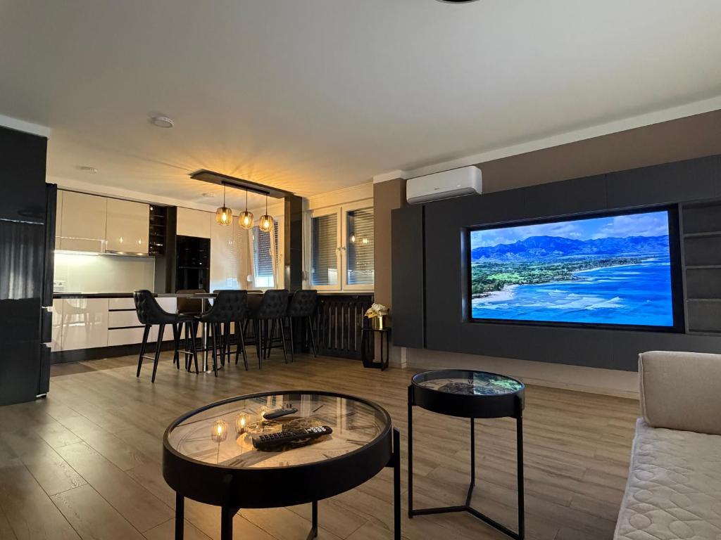 a living room with a couch and a tv on a wall at Bella Mela 2 in Tuzla