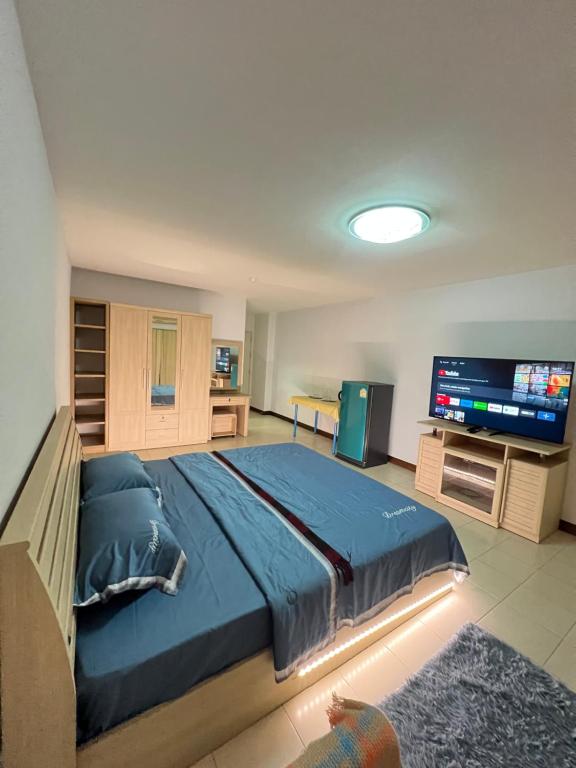 a bedroom with a large bed and a flat screen tv at Bts studio rooms in Bangna