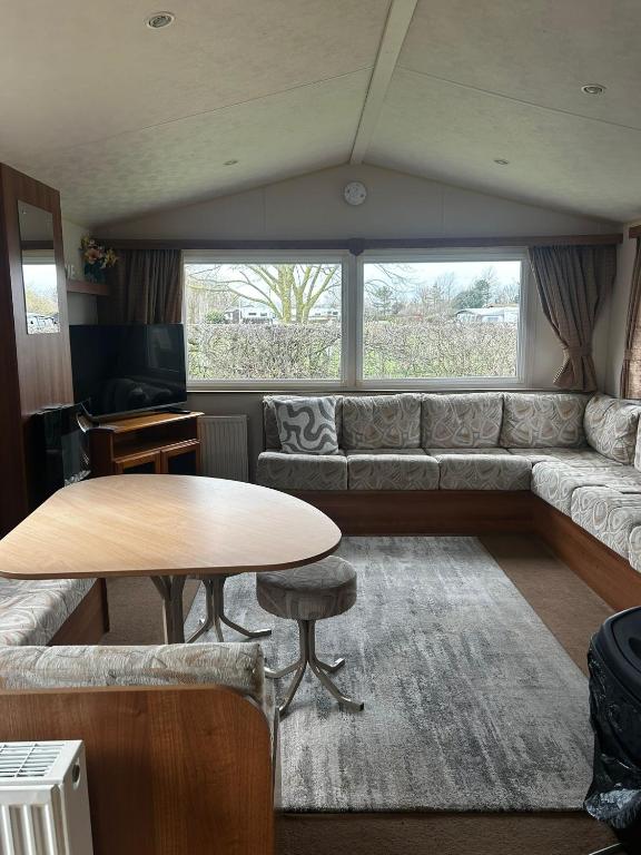 a living room with a couch and a table at Buttercup Retreat 298 northfield in Skipsea