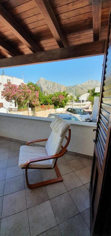 a chair on a balcony with a view of a boat at Residenza Zuc in San Vito lo Capo