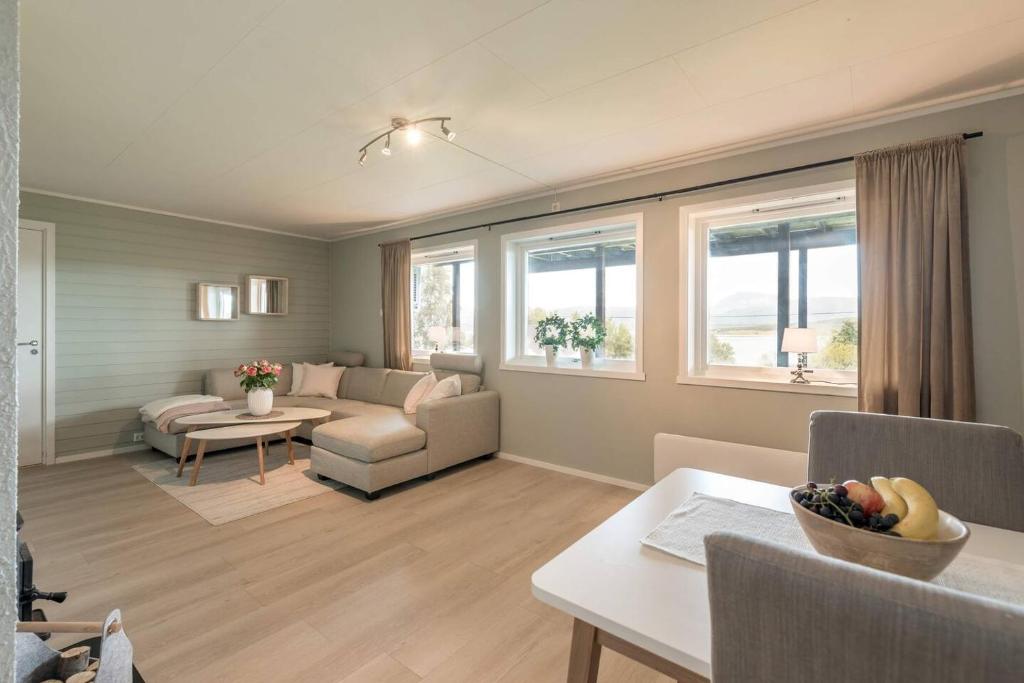 a living room with a couch and a table at Modern Fjord View Apt near City in Tromsø