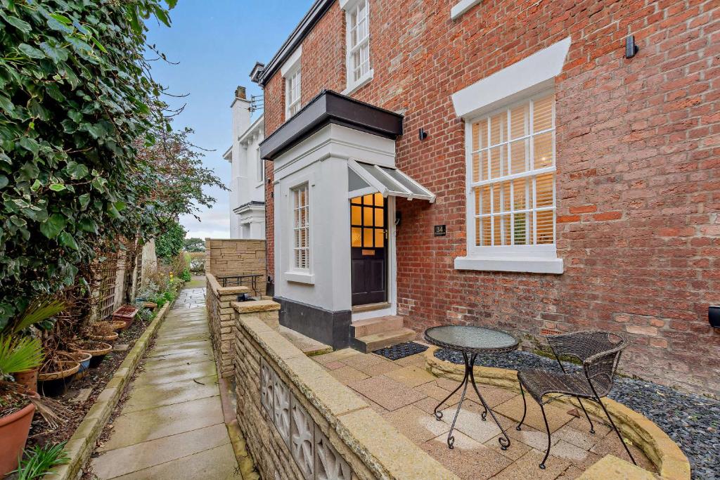 a patio of a brick house with a table at Swan House in Southport
