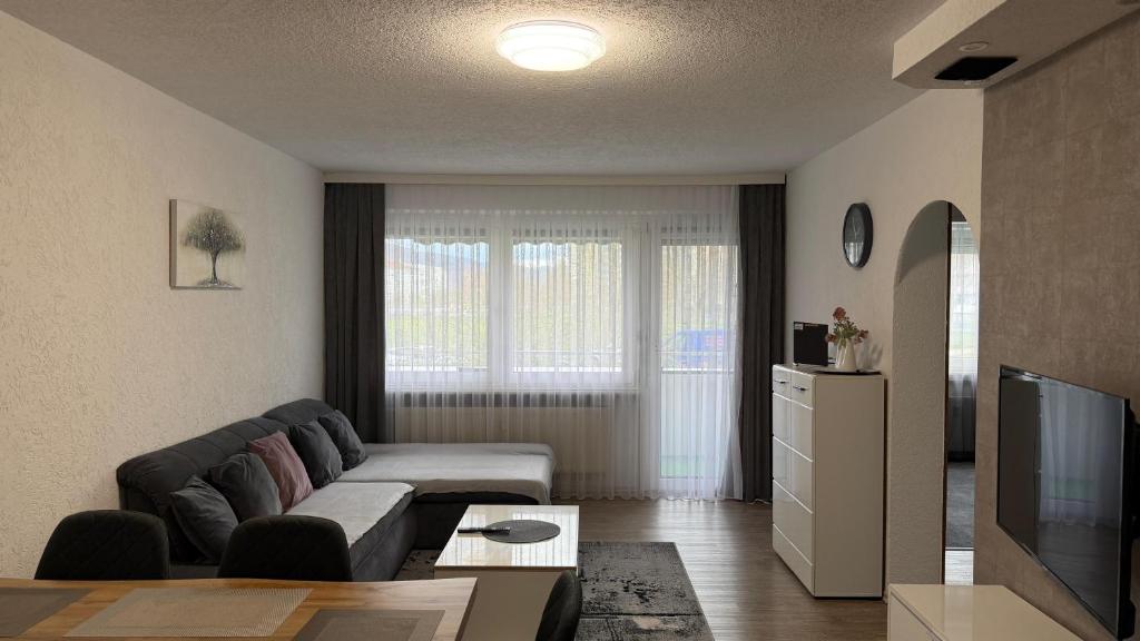 a living room with a couch and a television at Ferienwohnung City in Nollingen