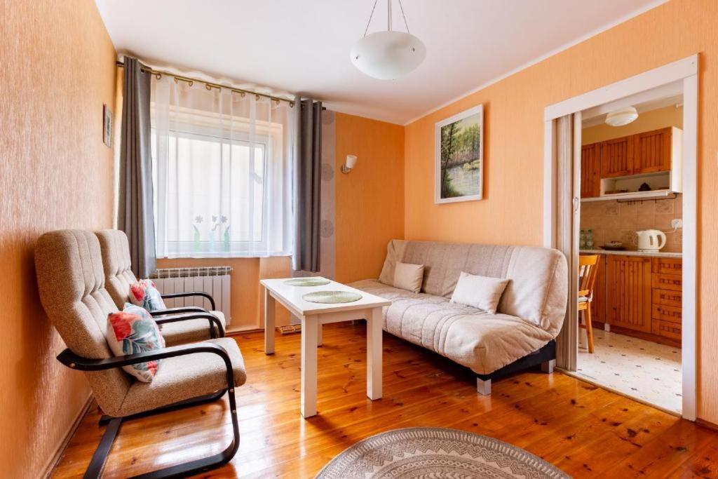 a living room with a couch and a table at Apartament pod mewą in Gdynia
