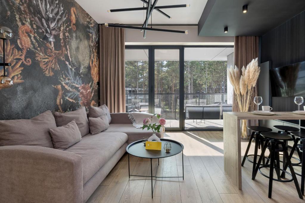 a living room with a couch and a table at Shellter Resort Apartment by Solarento in Rogowo