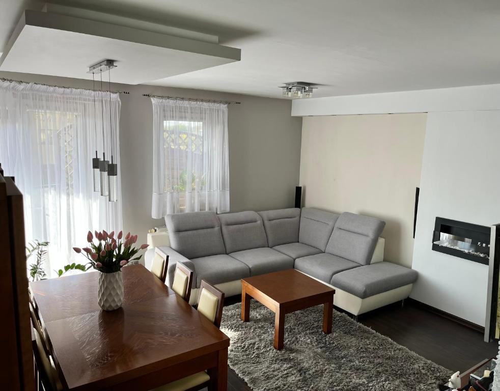 a living room with a couch and a table at Ogrodowa Apartament in Ciechocinek