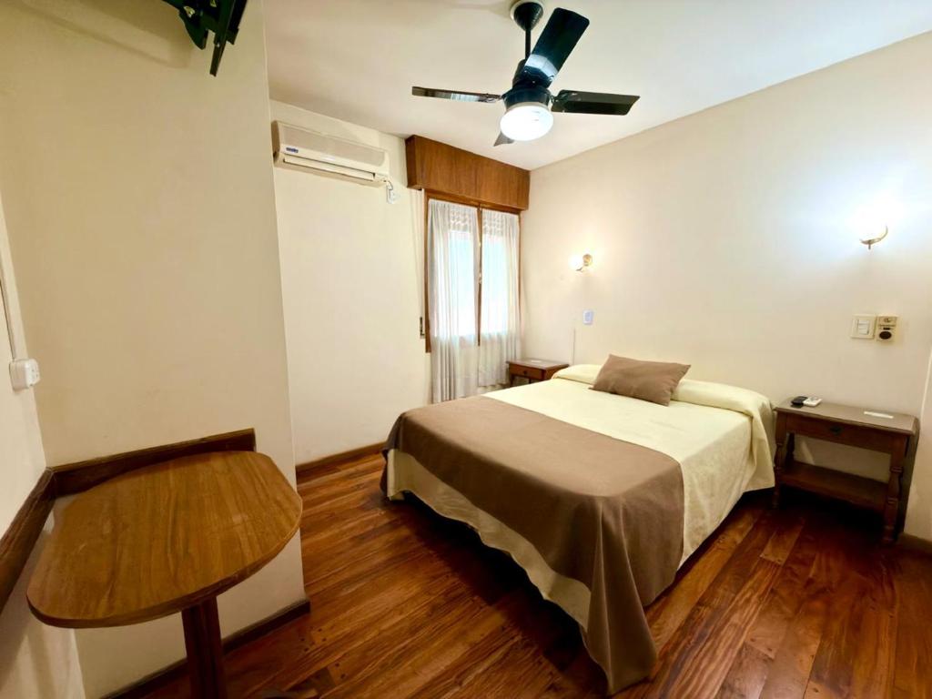 a bedroom with a bed and a table in it at Hotel Villa Inés Mendoza in Mendoza