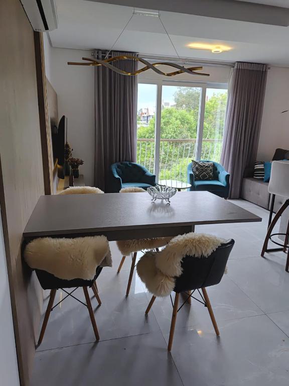 a living room with a dining room table and chairs at Edifício Capri , apto 405 Canela RS in Canela