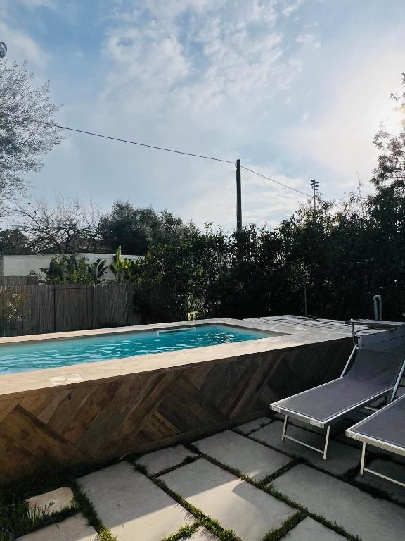 a swimming pool with two lawn chairs next to it at Respiro Greco in Syracuse