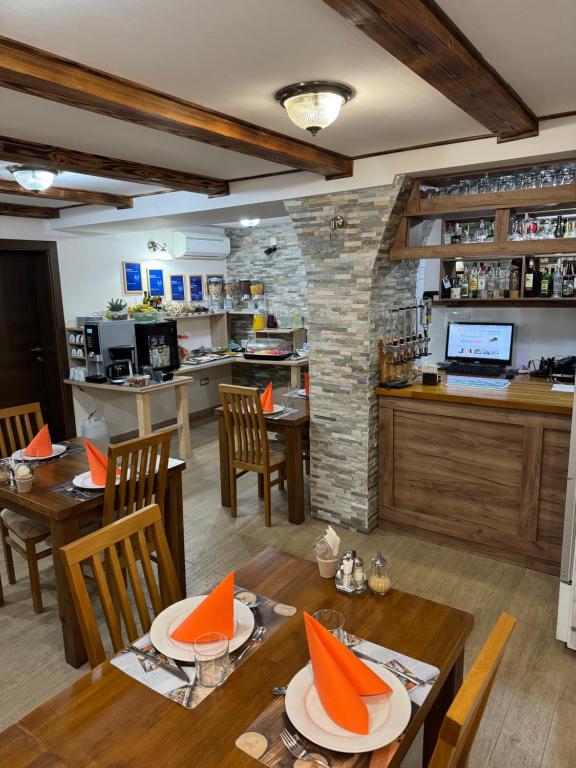 a restaurant with wooden tables and chairs and a kitchen at B&B Millenium House 2 in Jezerce