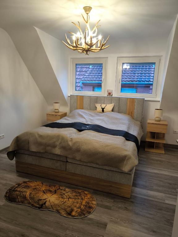 a bedroom with a large bed and a chandelier at Ferienwohnung Kampić Hirsch & Heimat in Rottweil