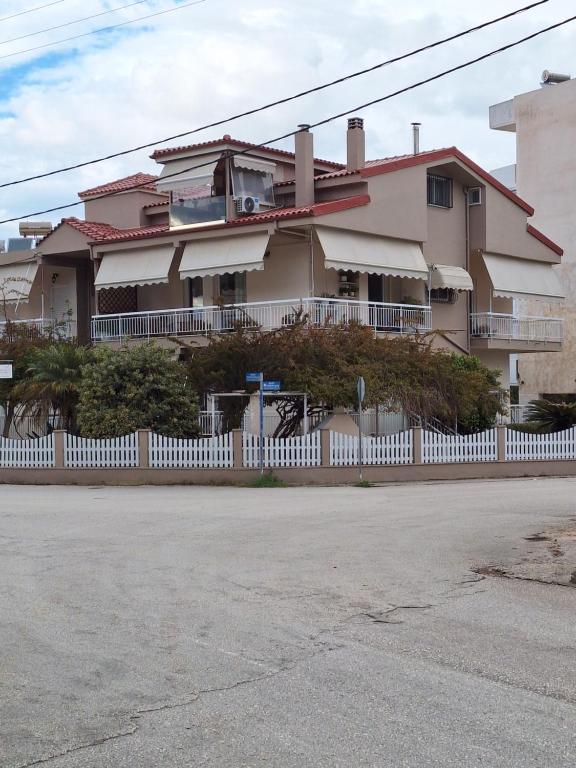 a house with a white fence in front of it at ILIANA apartments in Preveza