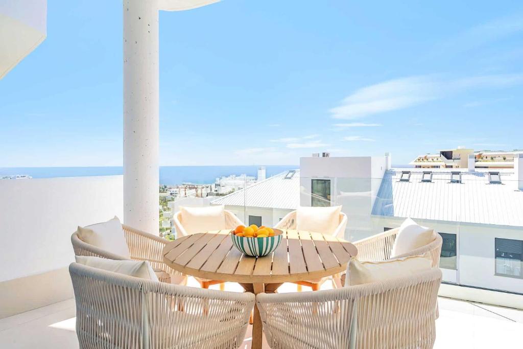 a table with chairs and a bowl of fruit on a balcony at Luxury Apartment Higueron in Fuengirola