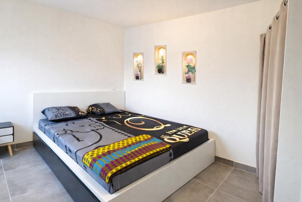 a bed with a football themed comforter in a bedroom at Sky Haven, 5Mins Orly Airport Apt 23 in Athis-Mons
