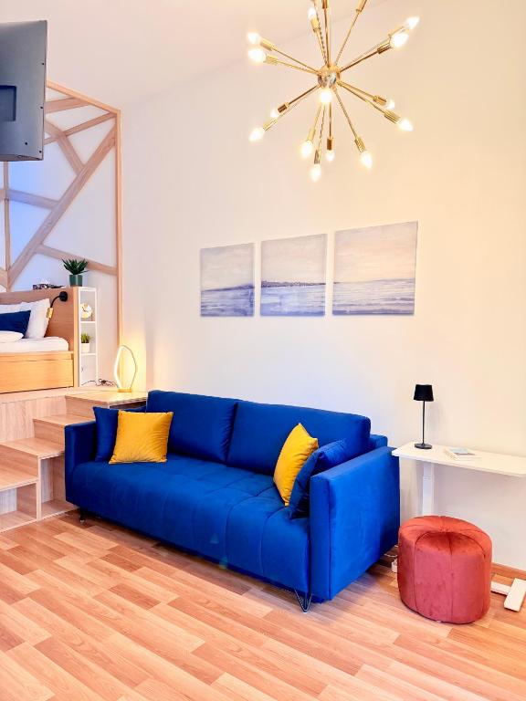 a blue couch in a living room with a ceiling at LelleBay in Balatonlelle