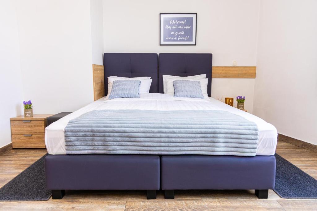 a large bed with a blue bed frame in a bedroom at Apartments R Sport boutique with free Parking in Sarajevo
