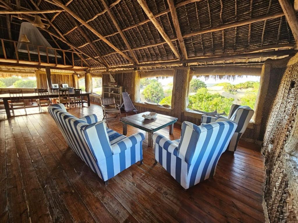 a room with blue and white chairs and a table at Bone Idle, Lamu Beach Home in Lamu