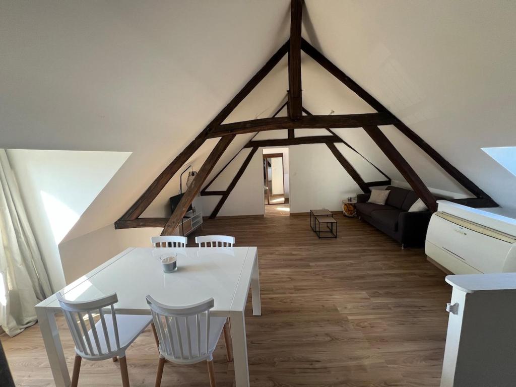 a living room with a white table and chairs at appartement de charme in Pont-Sainte-Marie