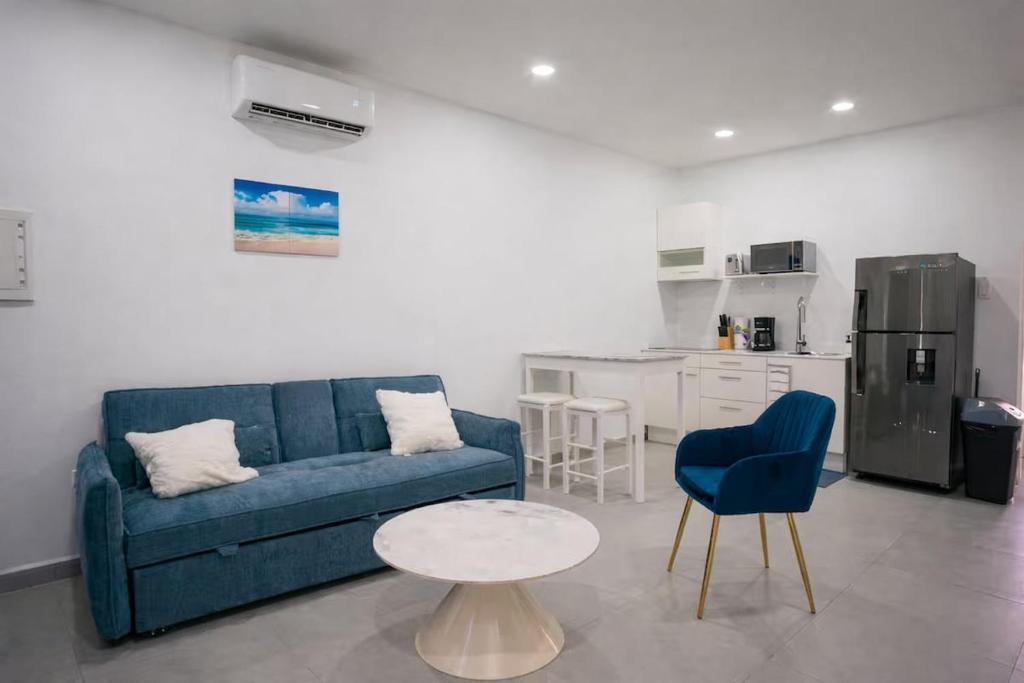 a living room with a blue couch and a table at Chiquitos Apartments in Savaneta