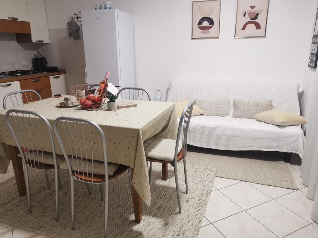 a dining room table with chairs and a table with fruit on it at Volme home in Banjole