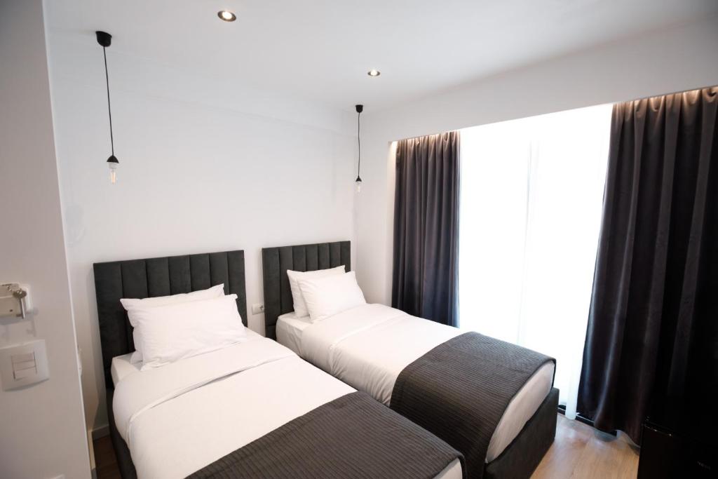 two beds sitting next to each other in a room at Silver Stone Studio Apartments in Gjirokastër