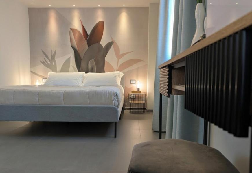 a bedroom with a bed with a painting on the wall at Etna Stone Rooms in Zafferana Etnea