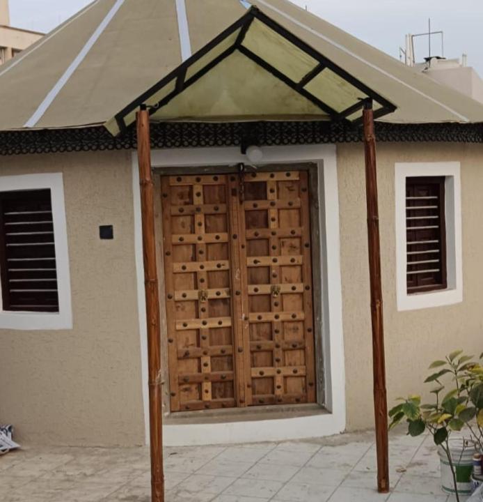 a wooden garage door in front of a house at Om Niwas Bhunga in Bhuj