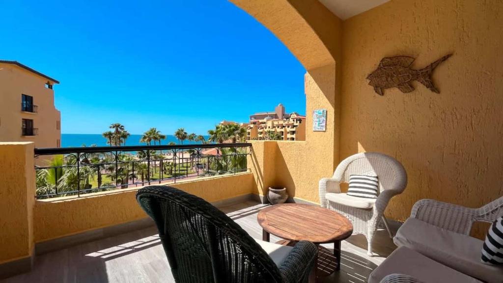 a balcony with chairs and a table and a view of the ocean at Gorgeous Third-Level Condo Princesa D-308 in Puerto Peñasco