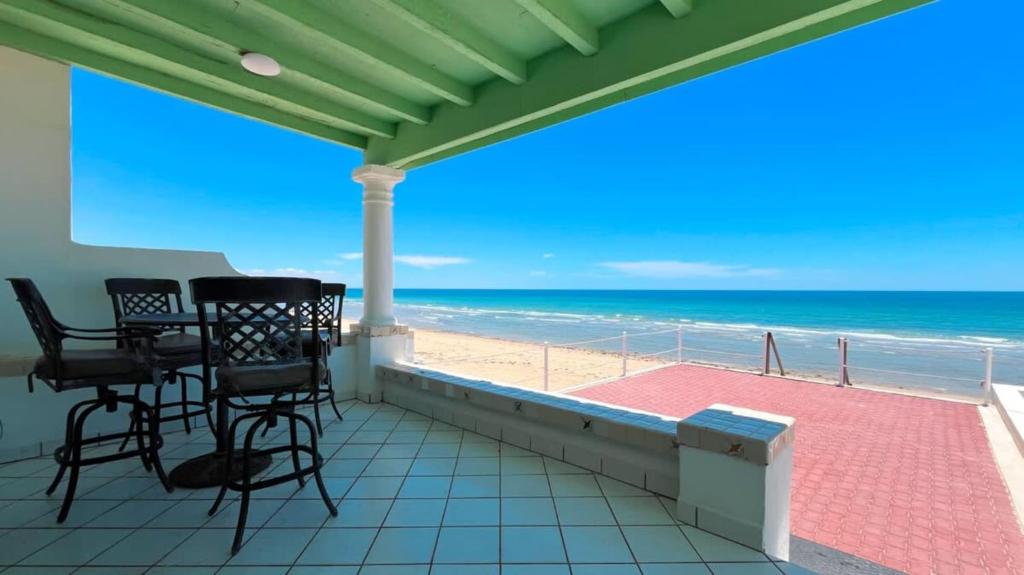 a balcony with chairs and a view of the beach at Beautiful Beachfront Condo Las Olas II 11 in Puerto Peñasco