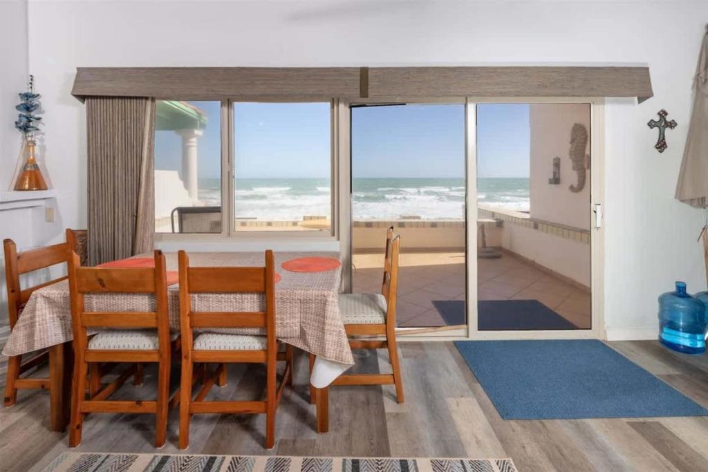 a dining room with a table with a view of the ocean at Cozy Beachfront Condo Las Olas II 10 in Puerto Peñasco
