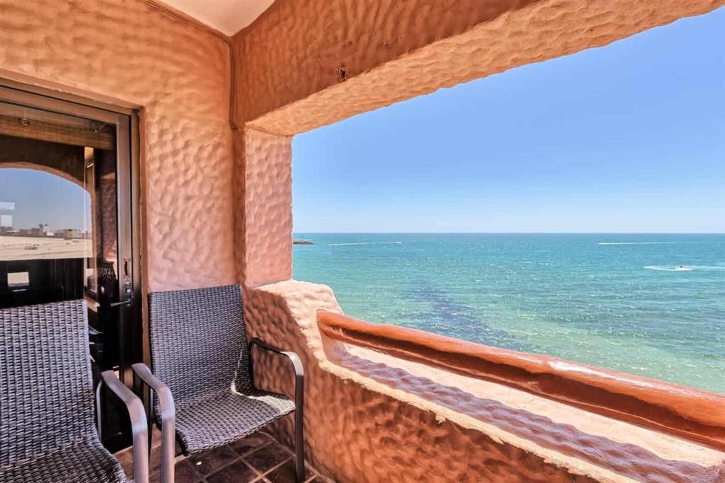 a room with two chairs and a view of the ocean at Charming Cozy Condo Great View Pinacate 404 in Puerto Peñasco