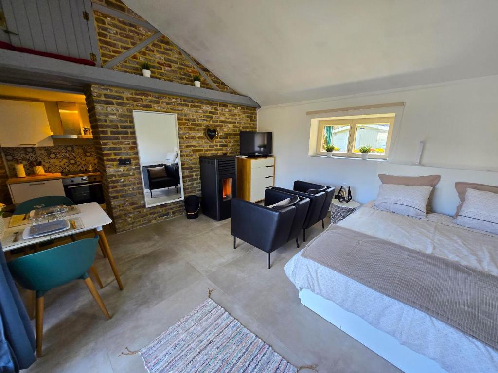 a bedroom with a bed and a desk and a kitchen at Haillodge-gîte nature in Ohey