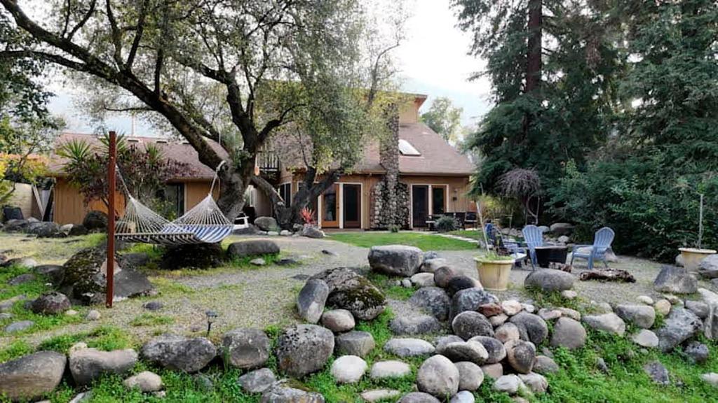 a rock garden with a hammock in a yard at Sequoia Cabin by the River in Three Rivers
