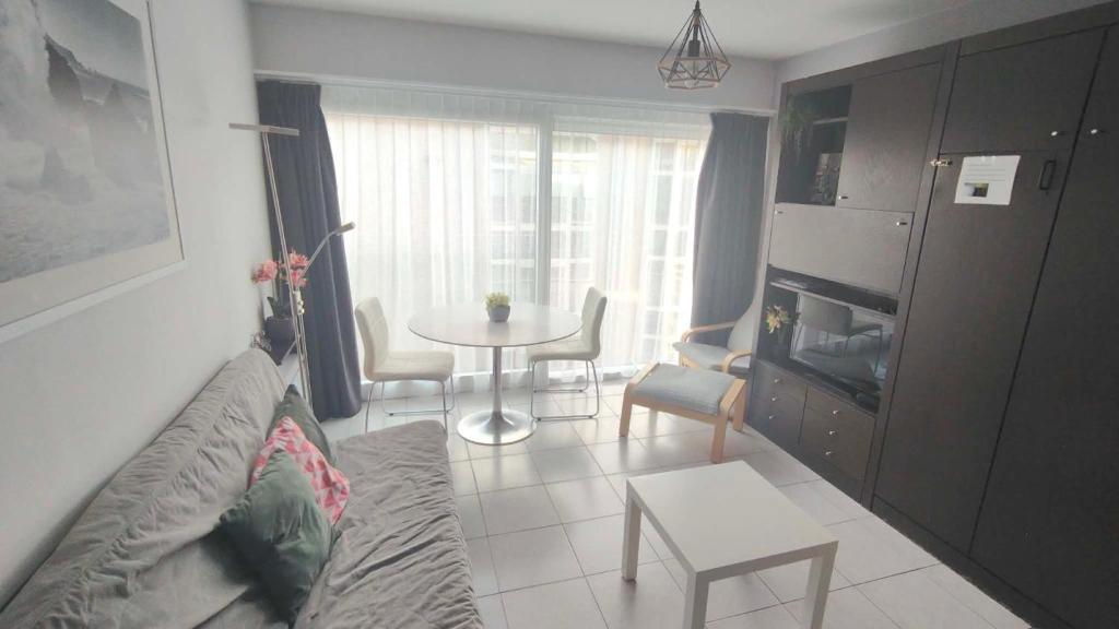 a living room with a couch and a table at Studio Algarve in Middelkerke