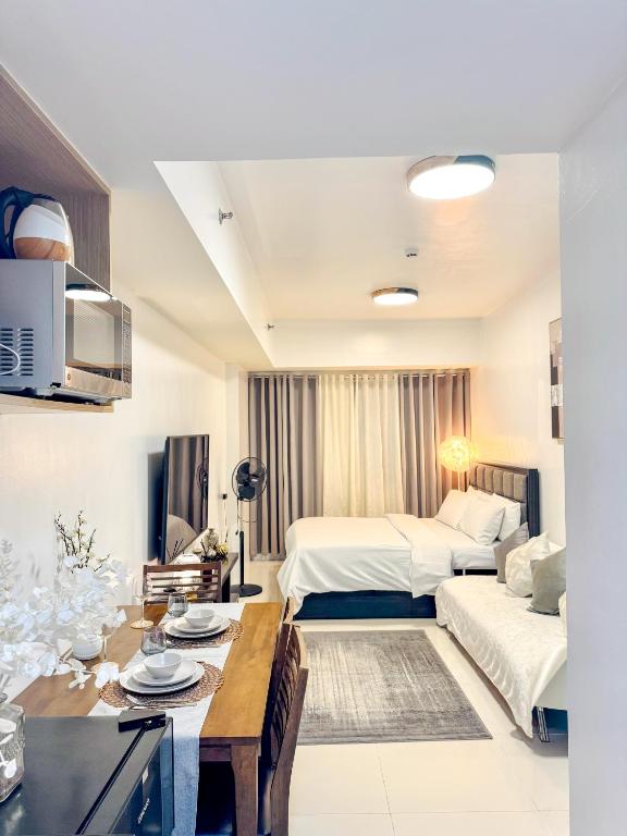 a hotel room with a bed and a dining table at La Montañosa at Brenthill Baguio Condo near City Center in Baguio