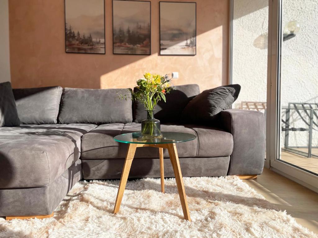 a living room with a couch and a table with flowers at Schönes Apartment Traumblick mit Balkon Bad Ems in Bad Ems