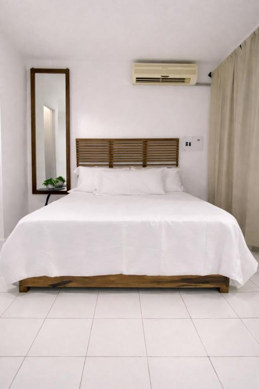 a bedroom with a large white bed with a mirror at The Oxford Suite in Kingston