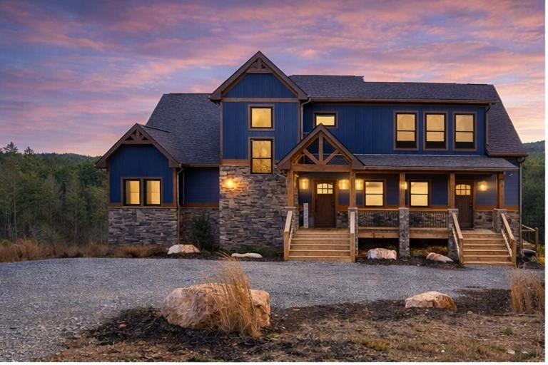a large blue house with rocks in front of it at Blue Salamander Lodge in Talking Rock