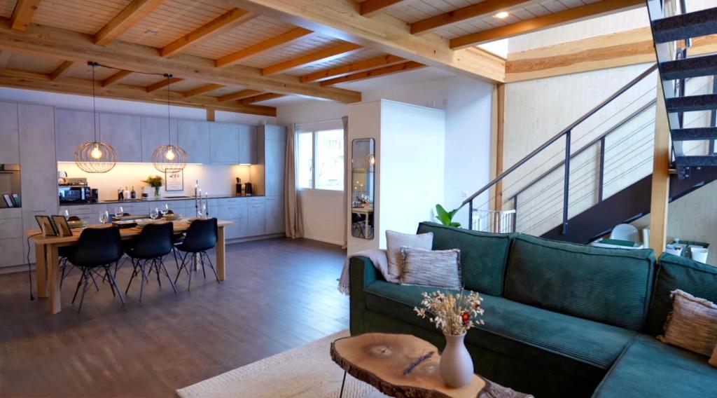 a living room with a green couch and a table at Louisa's Gallery - Whirlpool - Berge & Wandern - Abendruhe - familien- & gruppenfreundlich - 1h von Zürich in Alt Sankt Johann
