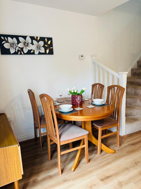 a wooden table with chairs and a dining room at Penuel 3-bedroom Retreat with workspace in Central Sutton-in-Ashfield in Sutton in Ashfield
