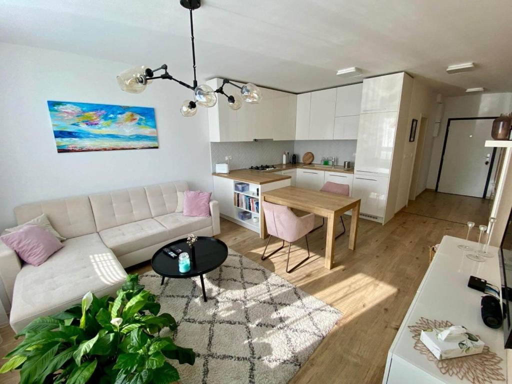 a living room with a white couch and a table at Bratislava, LUCAO Family Apartment, Balcony, Free Parking, Aircondition, 8km Old Town in Bratislava